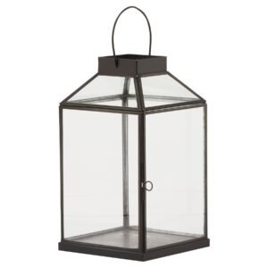 This is the Glass Top Small Black Lantern. This stylish black metal lantern is a contemporary style statement that will add not ambience and interest to a space. Additional sizes available in the same style for impactful staggered height displays. Finish the look with one of our realistic LED wax candles.