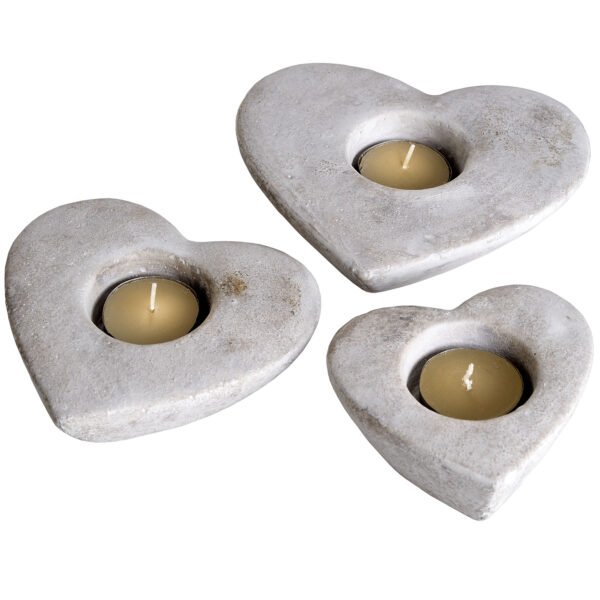 Set of three of stone effect heart shaped tea light holders with antiqued finish.