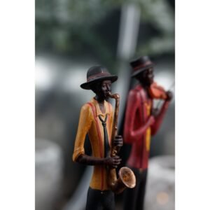 this elegant figurine captures the essence of musical artistry with its elongated silhouette and rich metallic finish in bronze and gold tones.  The musician's stance exudes confidence and style